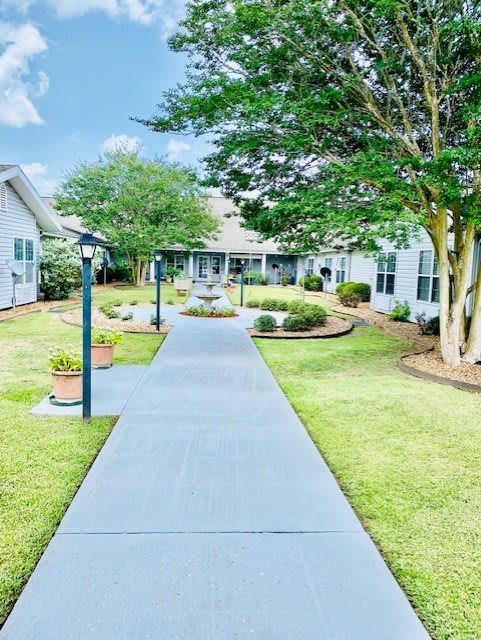 A well-maintained pathway leading through landscaped gardens surrounded by buildings.