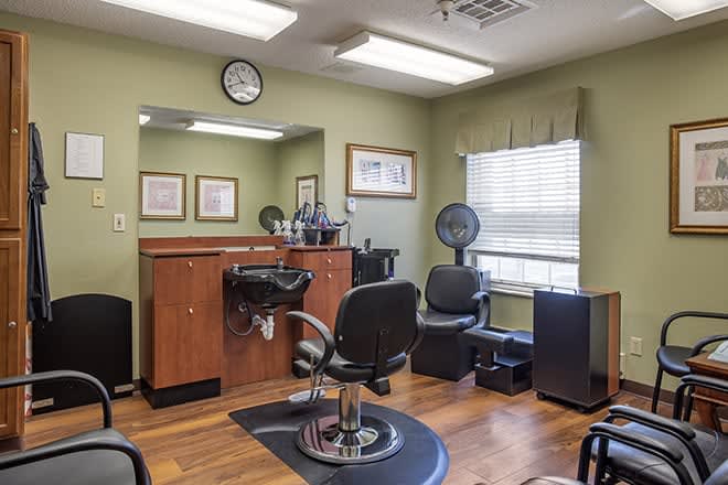 Interior view of a cozy hair salon with styling chairs, mirrors, and wooden floors.