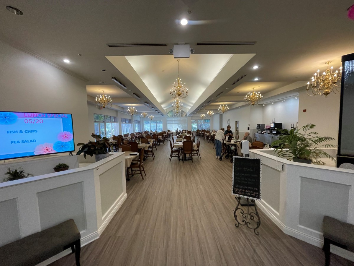 A spacious and elegantly decorated restaurant dining area with chandeliers.