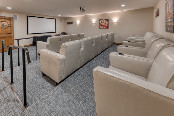 A cozy home theater with comfortable seating and a large projector screen.