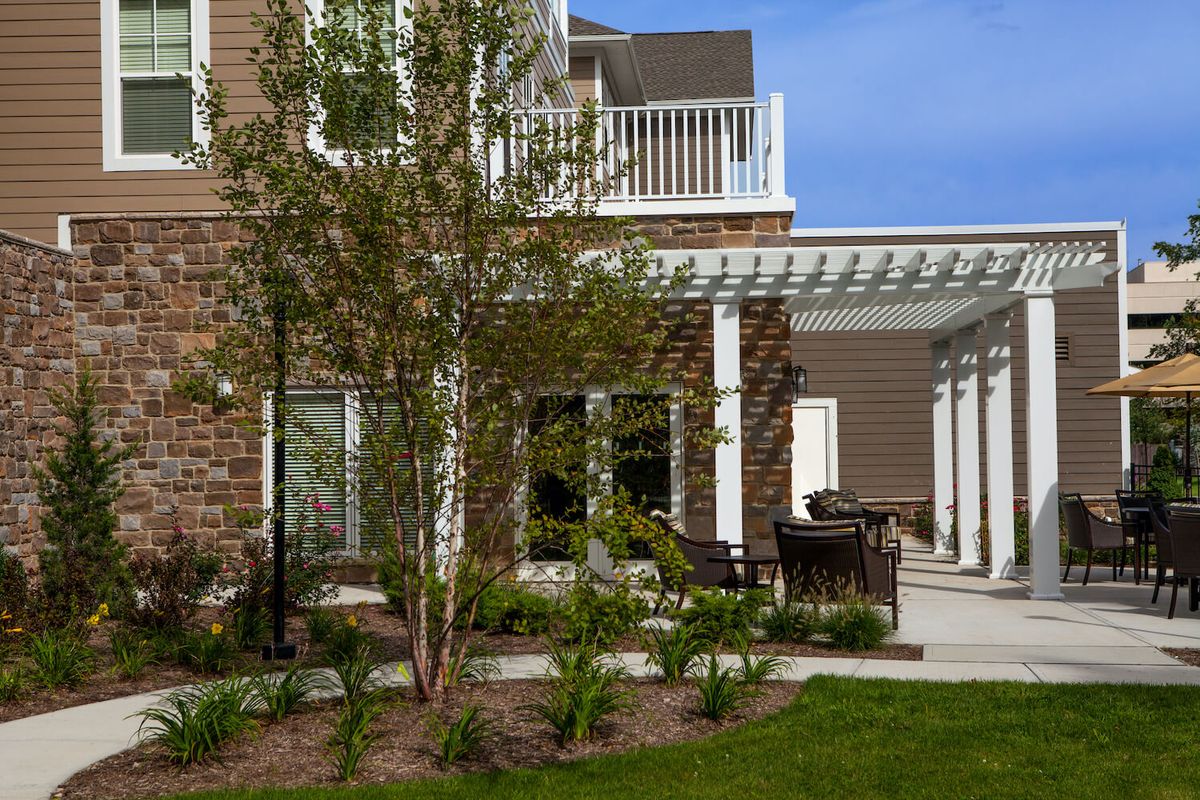 A beautiful house exterior featuring a patio with a pergola and well-maintained landscaping.