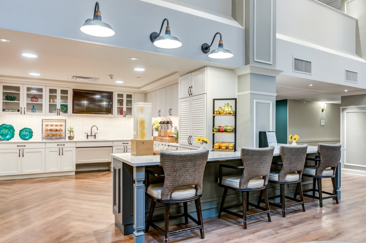 A modern kitchen with a bar-style seating area and elegant lighting fixtures.