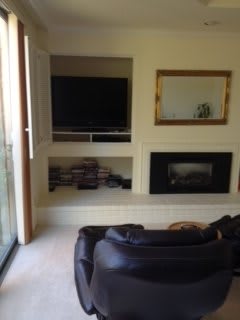 A cozy living room with a television, fireplace, and a sofa.