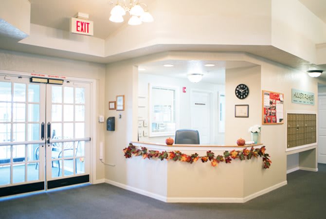A well-lit office reception area decorated with autumn-themed garlands.
