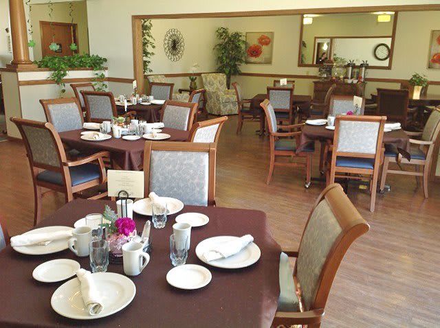 A neatly arranged dining area with tables and chairs, ready for guests.