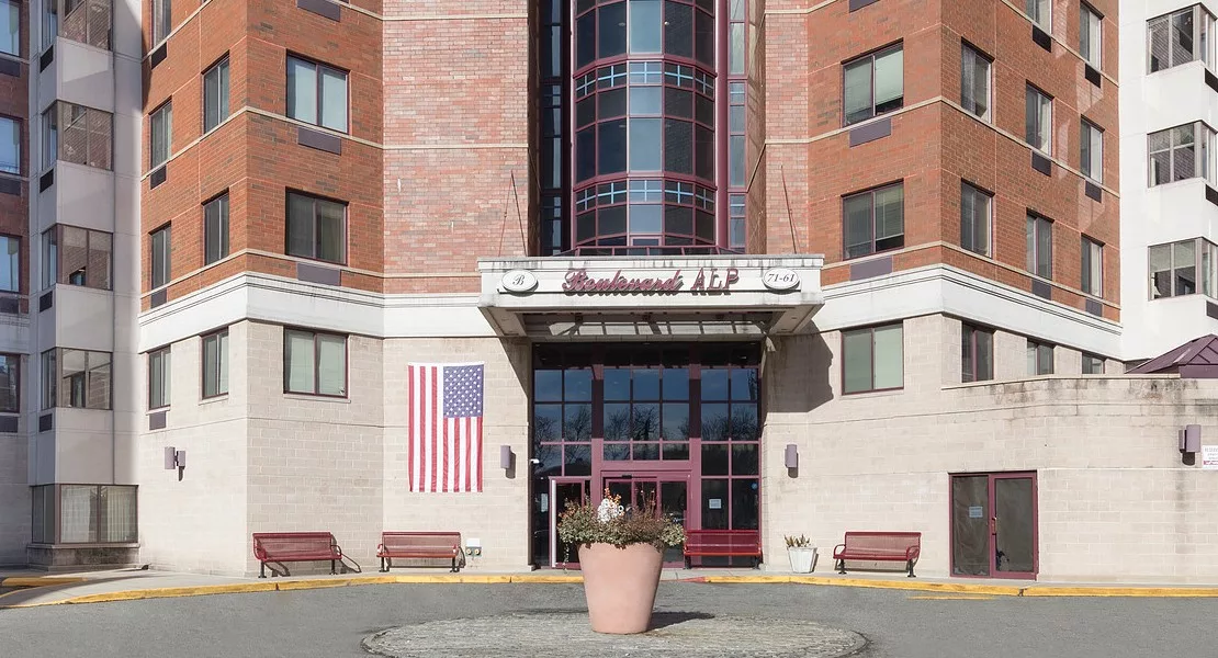 Front entrance of a hotel with an American flag displayed on the wall.