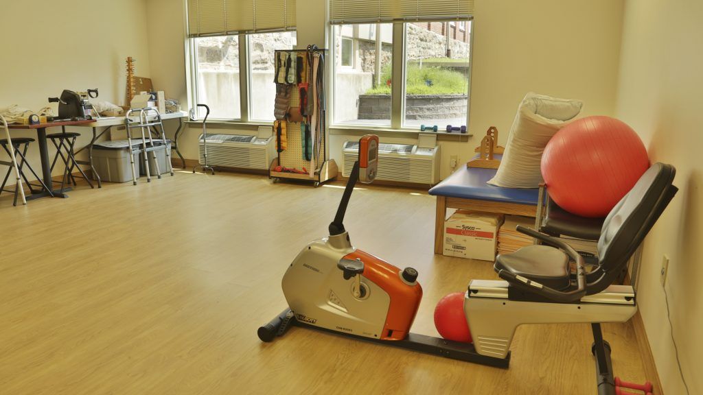 A therapy room equipped with exercise equipment, including an exercise bike.