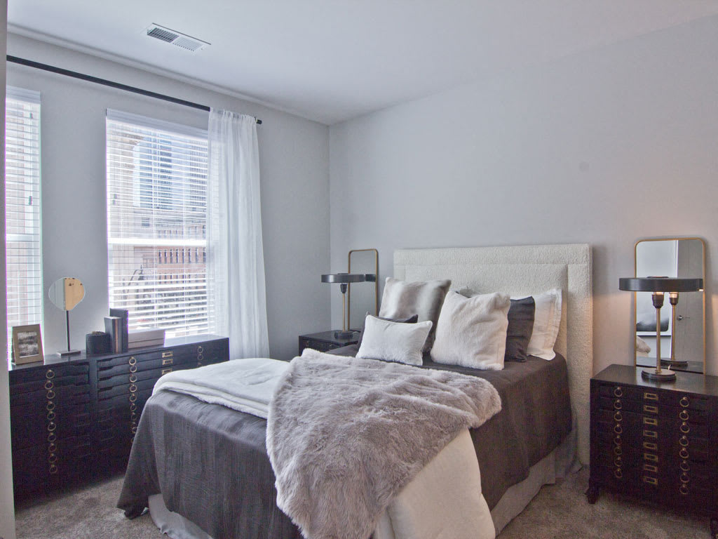 A cozy and well-decorated bedroom with a neatly made bed, featuring soft pillows and a plush blanket.
