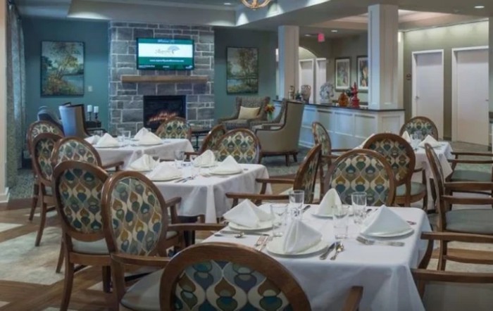 An elegantly set restaurant dining room with neatly arranged tables and chairs.