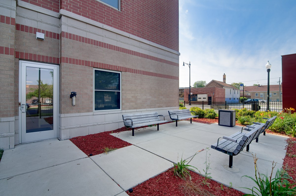 An outdoor area with benches and landscaping next to a brick building.