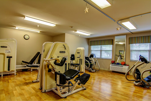 A well-equipped gym space featuring various exercise machines for fitness and rehabilitation.