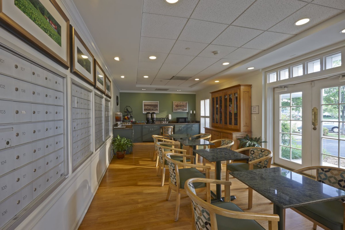 A cozy cafe interior with tables and chairs arranged neatly against a backdrop of soft lighting and elegant decor.