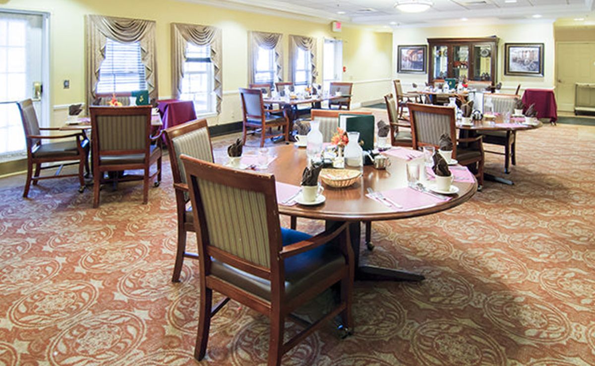 A well-furnished dining area with multiple tables and chairs arranged neatly in a bright, welcoming setting.