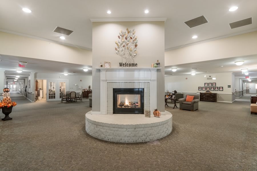 A spacious and elegant lobby interior featuring a central fireplace with surrounding seating areas.