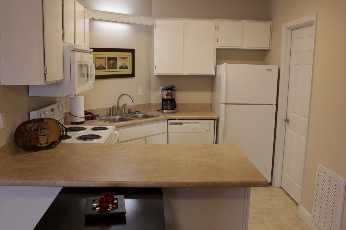 A cozy kitchen with white cabinets and modern appliances.