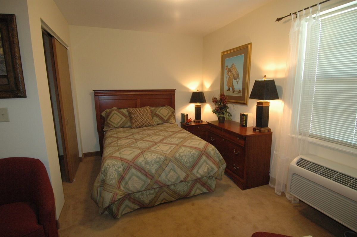 A cozy bedroom with a double bed, lamps, and decorative elements.
