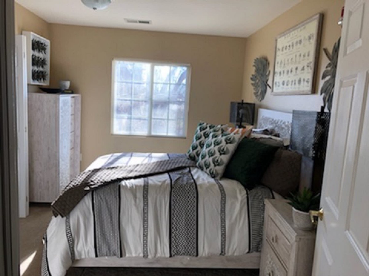 A cozy bedroom with stylish decor and natural light.