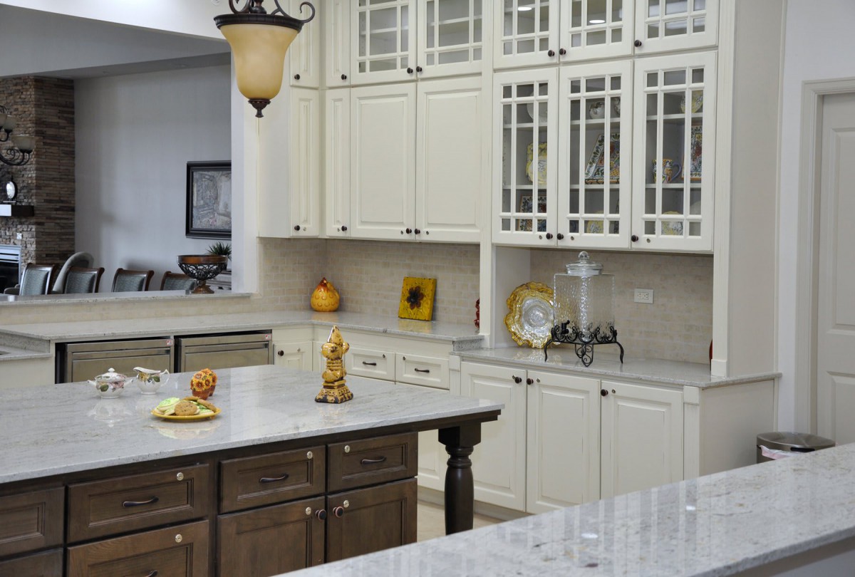 A modern kitchen featuring white cabinets, a central island, and stylish decor.