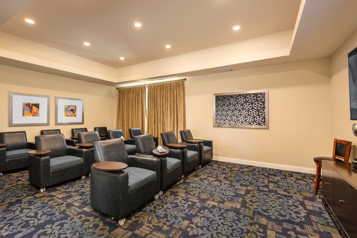 A cozy indoor theater room with recliner seating and ambient lighting.