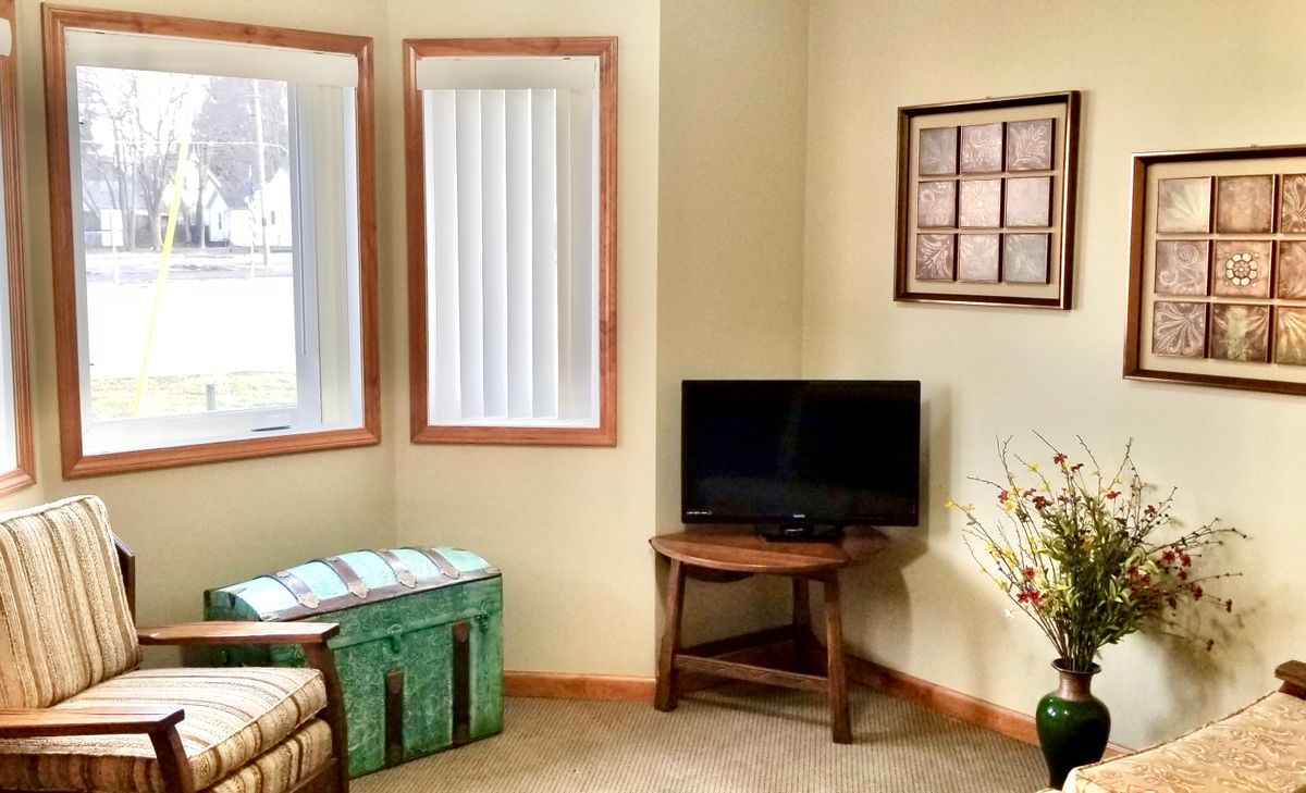 A cozy living room corner with a television and natural light.