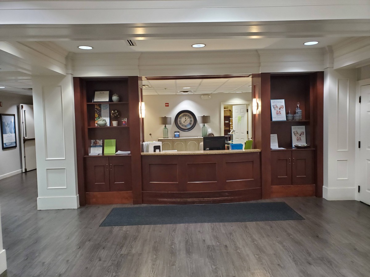 An inviting hotel reception desk with dark wood accents and warm lighting.