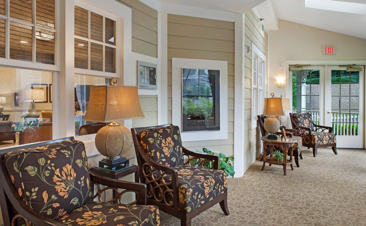 A cozy living room with floral-patterned chairs and warm lighting.