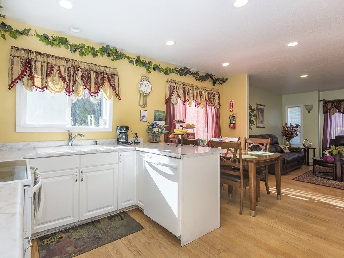 A cozy kitchen and dining area with white cabinets and a warm, inviting atmosphere.