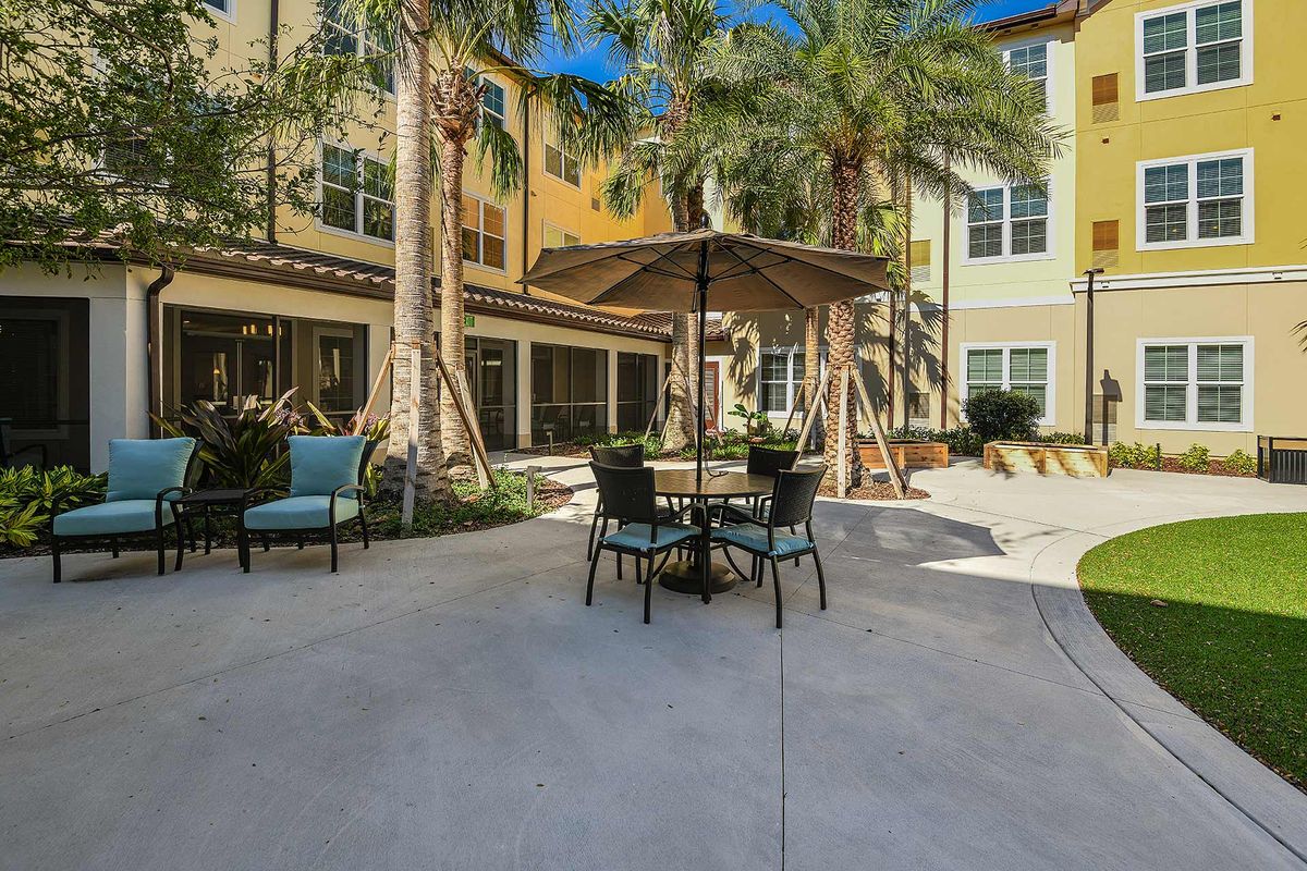 Outdoor patio area with seating and palm trees.