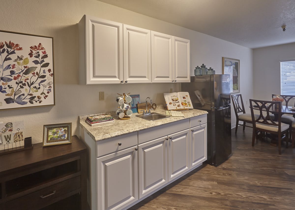 A cozy kitchen space with white cabinets and a decorative countertop.