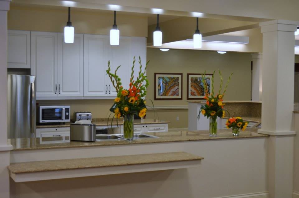 A modern kitchen interior featuring decorative flowers on the countertop and stylish lighting fixtures.
