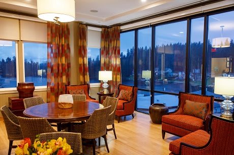 A cozy living and dining area with large windows overlooking a scenic evening view.