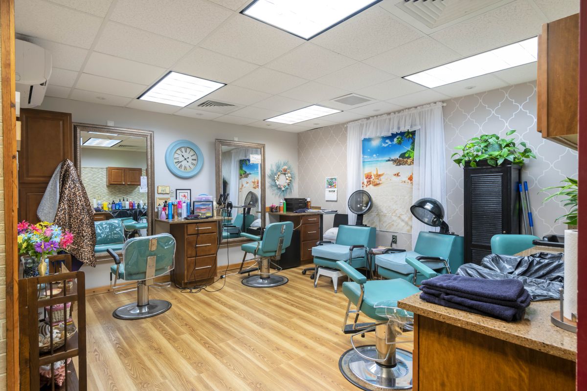 Interior view of a hair salon with chairs, mirrors, and salon equipment.