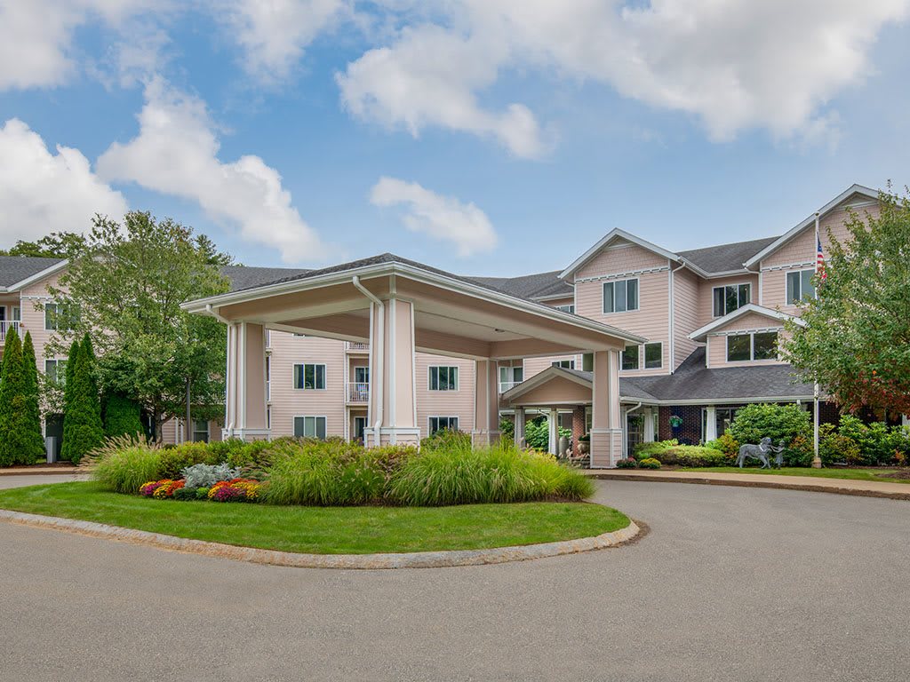 A residential building with a grand entrance and well-maintained gardens.