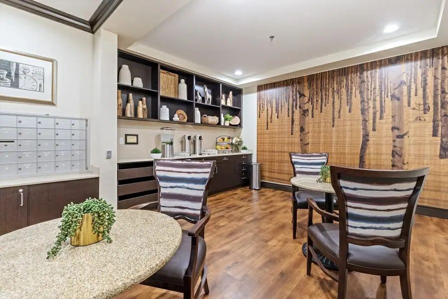 A cozy dining area with modern decor, featuring wooden flooring and neatly arranged shelves.