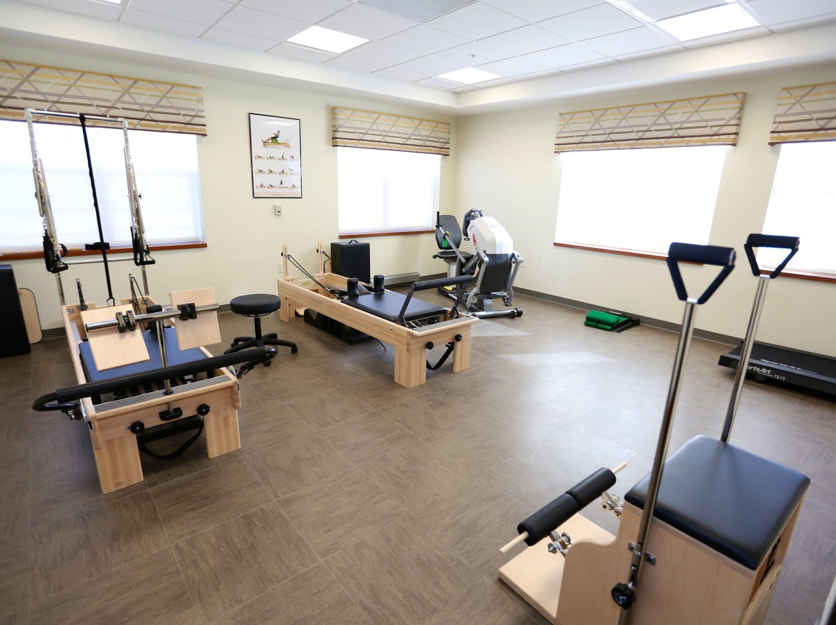 A spacious exercise room equipped with Pilates machines and workout gear.