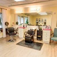 A well-lit hair salon interior with styling chairs and mirrors.