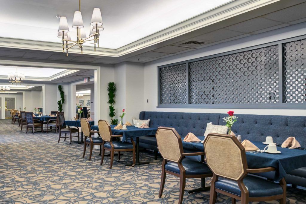 A luxurious dining area with blue upholstered seating and elegant chandeliers.
