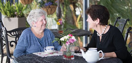 Two women enjoying a conversation over tea.