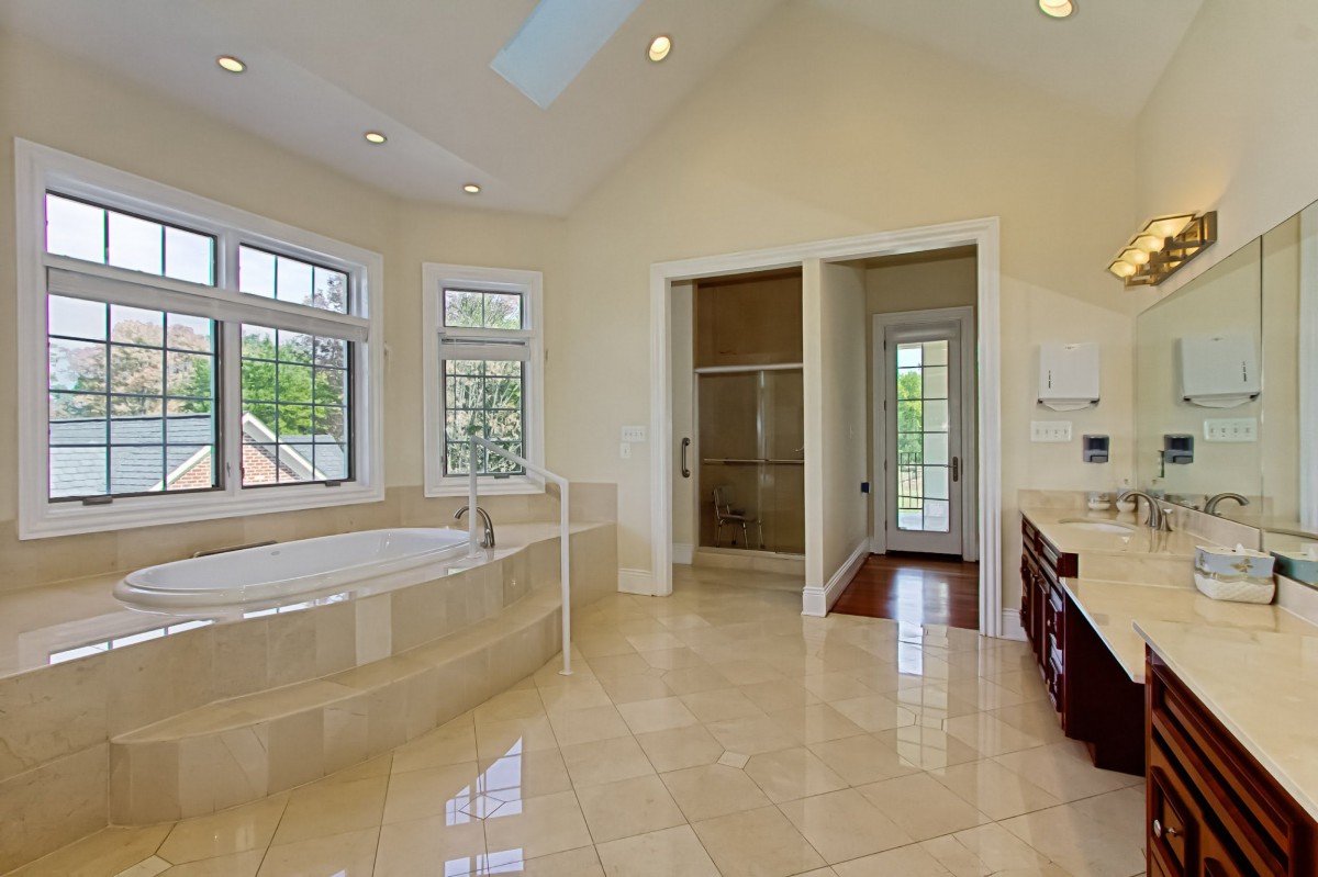 A spacious and luxurious bathroom with a large bathtub and tiled floor.