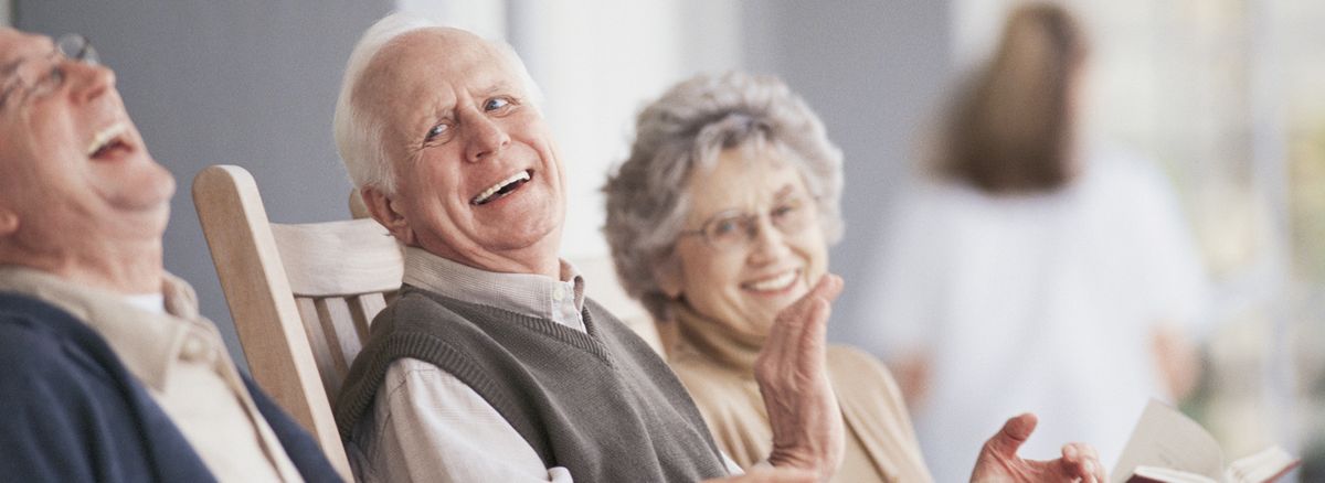 Elderly couple smiling and enjoying a moment together indoors.