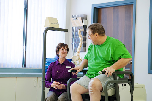 A patient engages in therapy with the assistance of a healthcare professional in a rehabilitation setting.