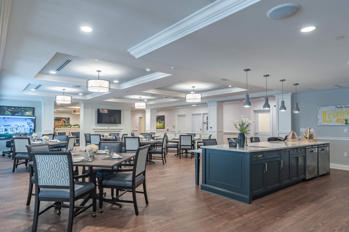 A modern dining area with elegant lighting and wood flooring.