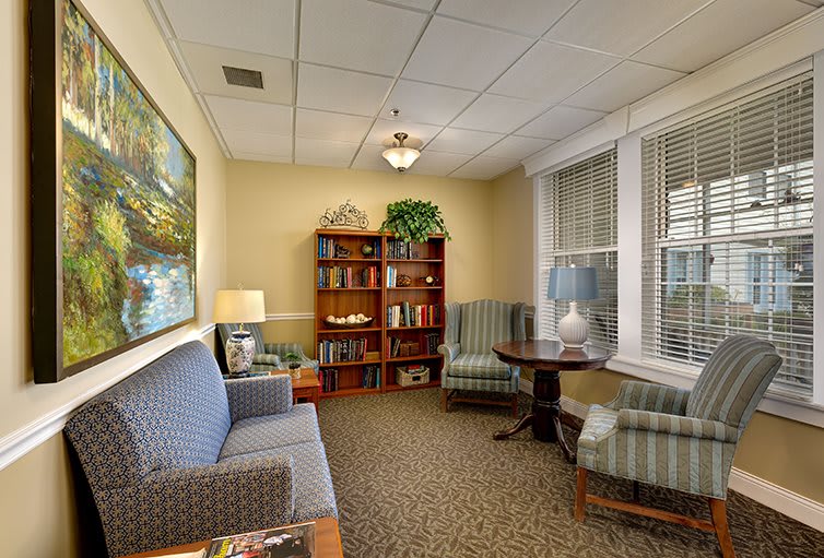 A cozy living room interior with seating area and bookshelf.