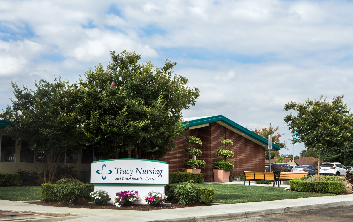 A nursing home building with well-maintained landscaping and clear signage.