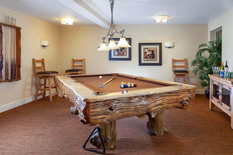 A cozy game room featuring a wooden pool table and stylish decor.