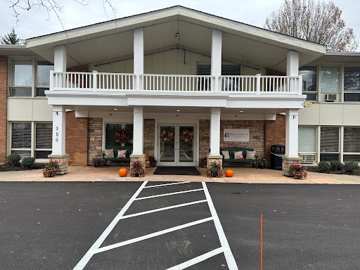 A charming two-story building with a welcoming front entrance and balcony, surrounded by seasonal decorations.