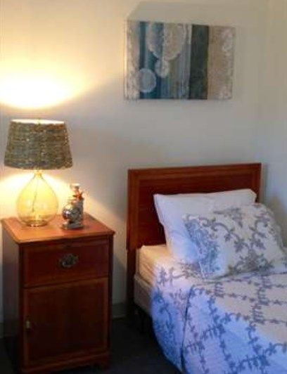 Cozy bedroom with a bed and a nightstand featuring a lamp.