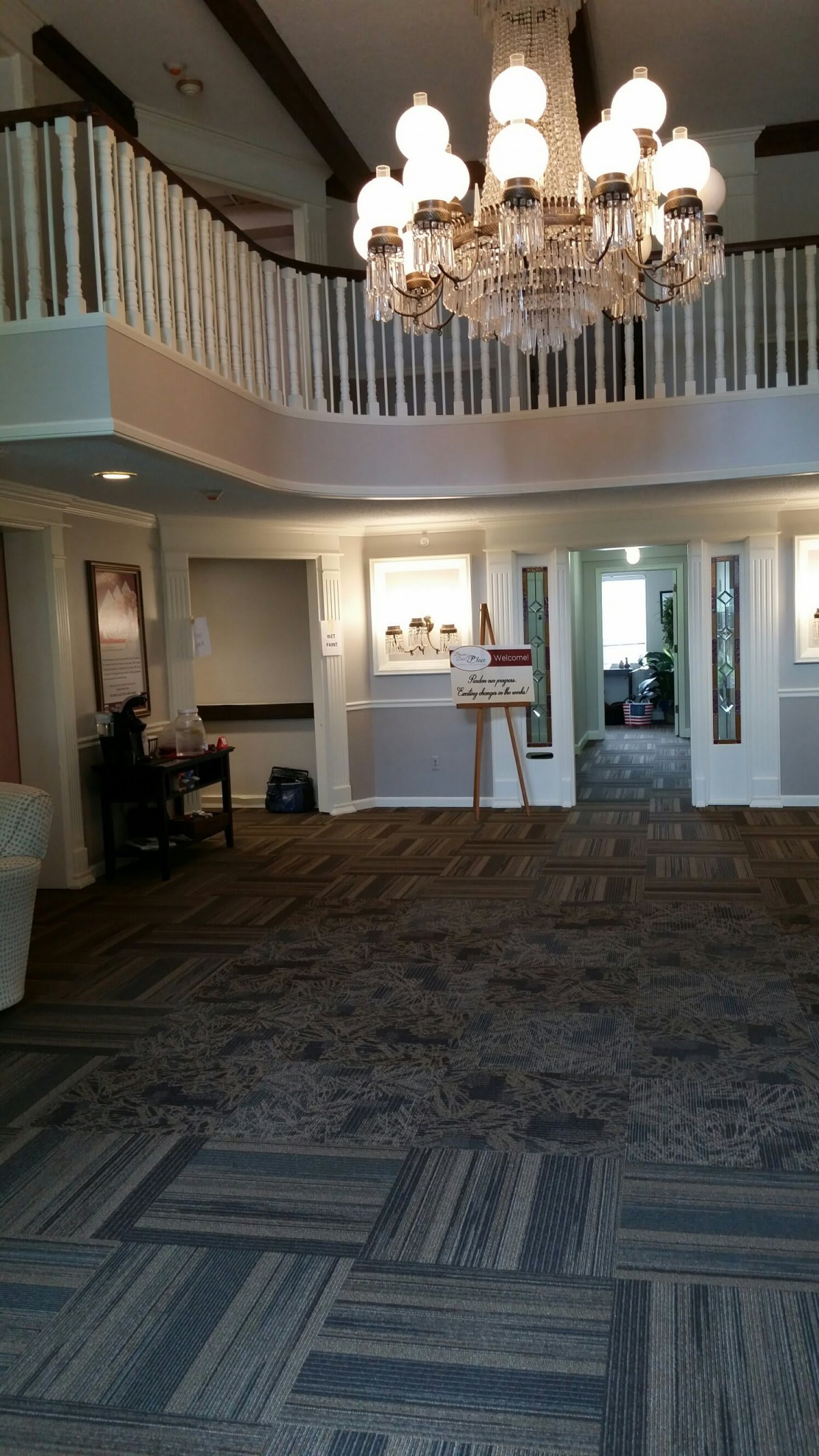 A spacious lobby area with carpeting, furniture, and a staircase.