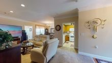 A welcoming living room with comfortable seating and a view into the kitchen.
