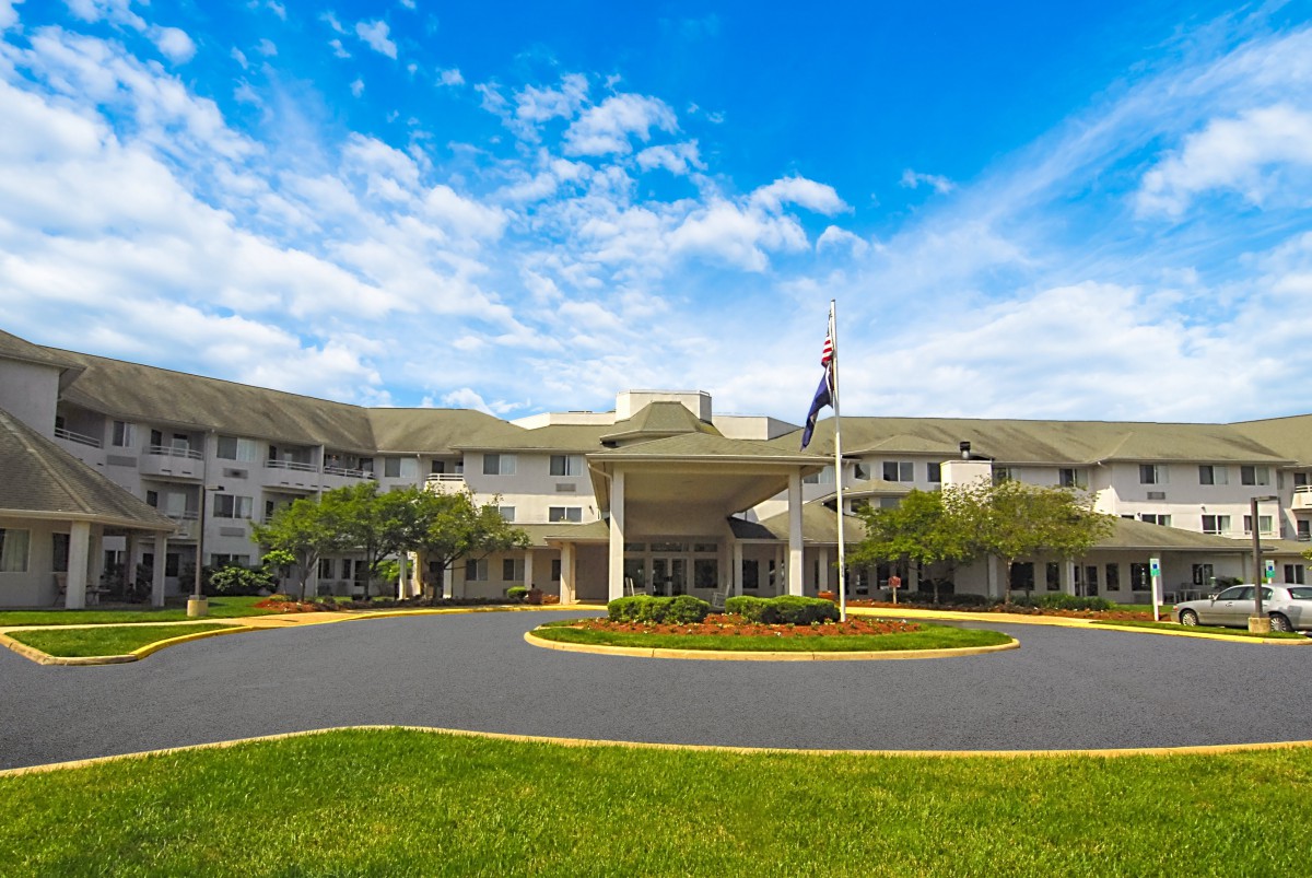 A large building with a prominent entrance under a partly cloudy sky.